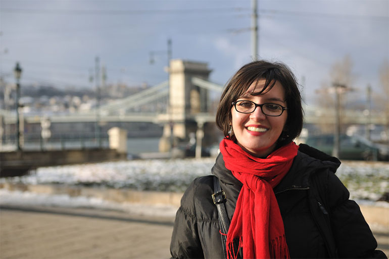 Implanttimatkojen hammaspotilas Budapestissa hymyilee, taustalla Ketjusilta.